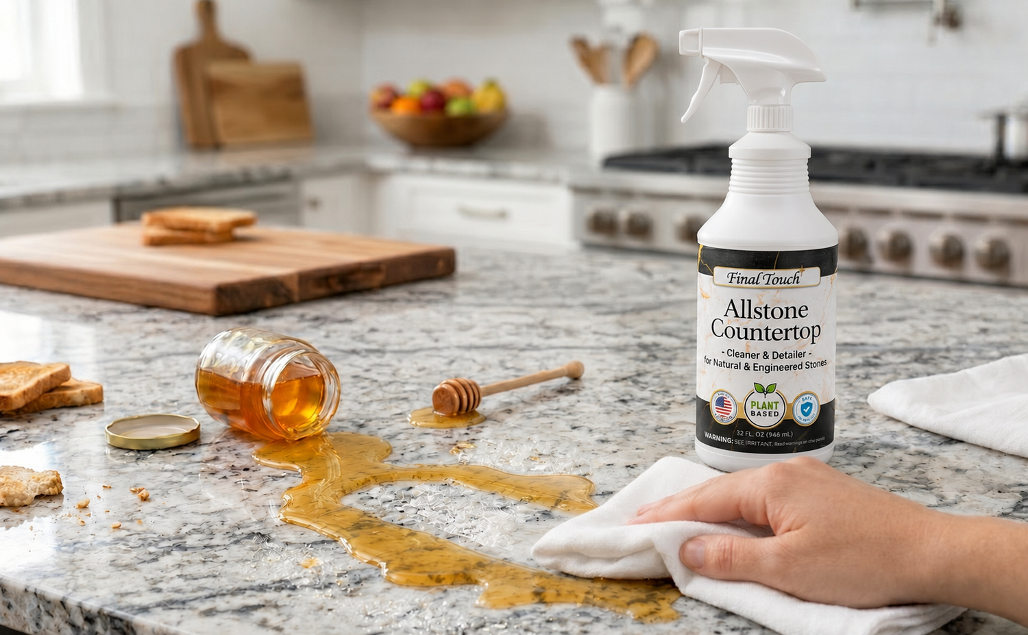 Modern kitchen countertop with spilled honey being wiped clean beside a bottle of Final Touch Allstone Countertop Cleaner on a granite surface.